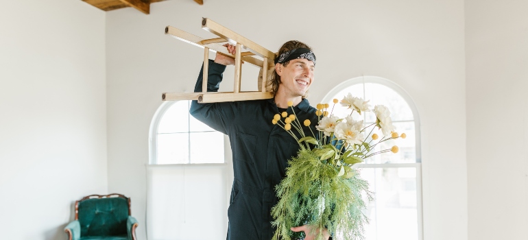mover holding flowers and a stool
